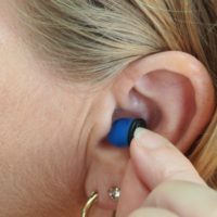 woman inserting hearing aid