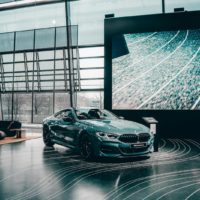 Elegant luxury coupe showcased in a modern Munich auto showroom with glass architecture.