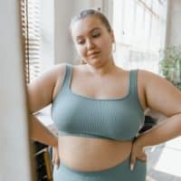 Plus size woman embracing body positivity in stylish activewear, indoors.