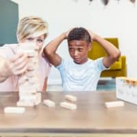 A mother and son share a fun bonding moment playing Jenga indoors.