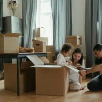 A family unpacks moving boxes in their new home kitchen, creating a cozy atmosphere.