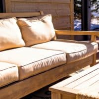 A comfortable outdoor patio seating area with cushions, offering a cozy and modern touch to any home.
