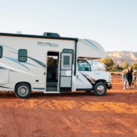 white and brown rv trailer on brown sand during daytime
