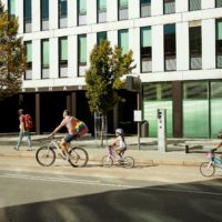 Family biking on city street in Innsbruck, Austria