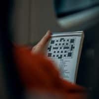 Woman doing a crossword on the train