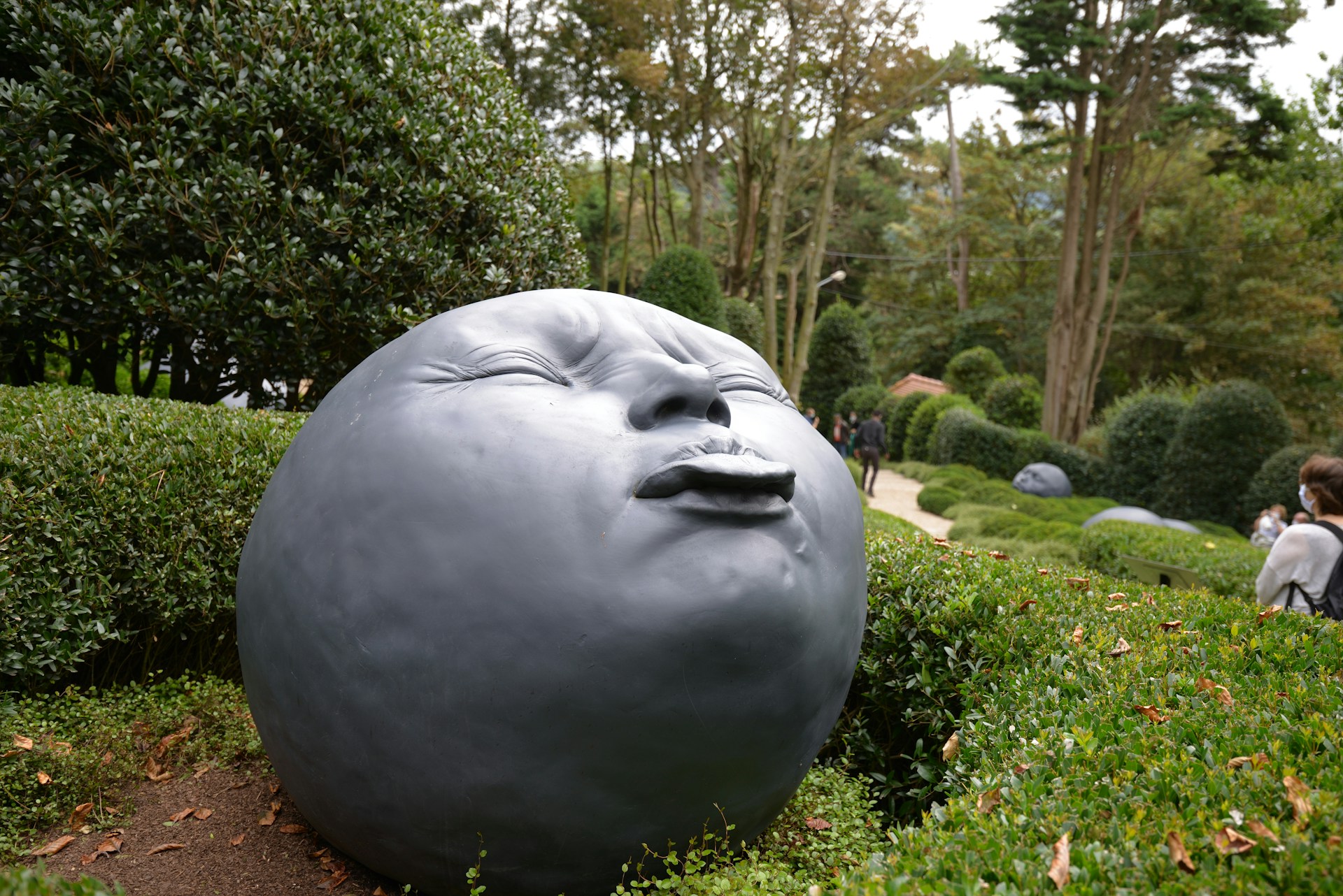 gray round statue near green trees during daytime