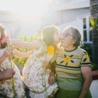 Heartwarming outdoor scene of twin girls with their grandparents, sharing love and happiness.