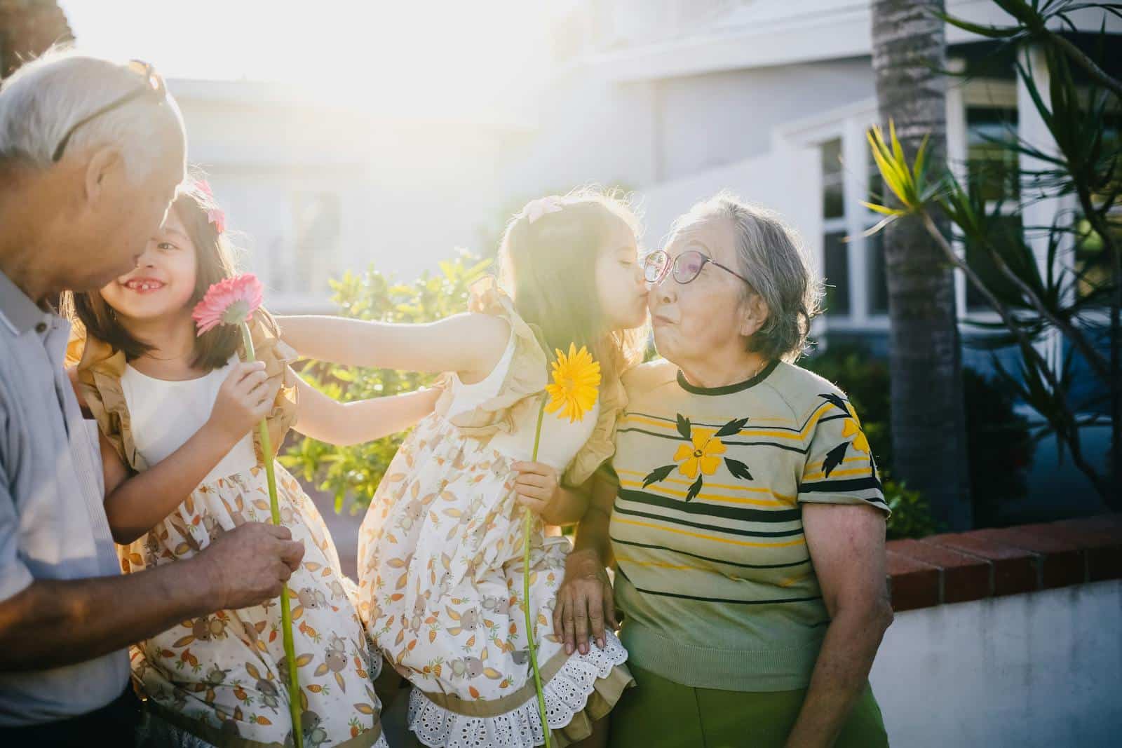 Heartwarming outdoor scene of twin girls with their grandparents, sharing love and happiness.