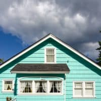 a blue house with white windows and a black roof